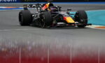 Red Bull Racing Formula 1 car taking a tight corner on a race track, sponsor logos visible on the car and barriers in the background