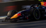Red Bull Racing Formula 1 car zooming on track, orange nose with Red Bull logo and sponsor decals visible.