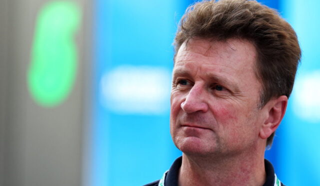 Man with short brown hair wearing a dark polo and a lanyard, looking to the right outdoors at an event.