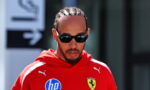 Man with cornrow braids wearing black sunglasses and a red Ferrari hoodie with an HP logo on the chest.