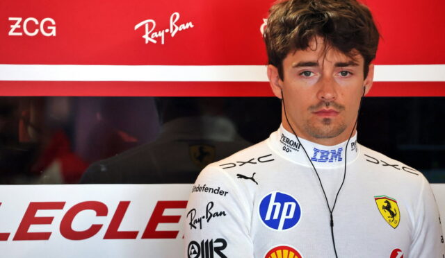 Portrait of a Ferrari Formula 1 driver in a white racing suit with sponsor logos, wearing earphones against a red backdrop.