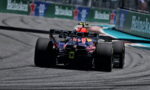 Red Bull Formula 1 car seen from behind on a race track, rear wing with ORACLE text and Heineken banners along the barrier nearby