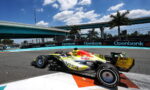 Red Bull Racing Formula 1 car (no. 41) on a sunlit race track, blue sky, with Openbank sponsor banners along the barrier.