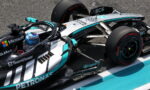 Mercedes-AMG Petronas Formula One car on a race track with teal-black livery and sponsor decals like Microsoft and TeamViewer on the sideplanks.