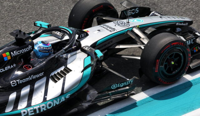 Mercedes-AMG Petronas Formula One car on a race track with teal-black livery and sponsor decals like Microsoft and TeamViewer on the sideplanks.