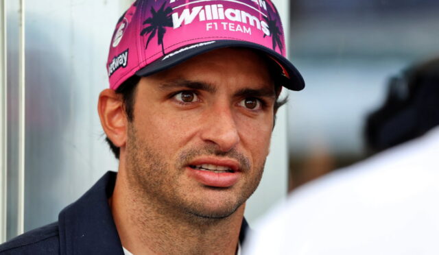 Man wearing a pink Williams F1 Team cap looking slightly to the right during an interview.
