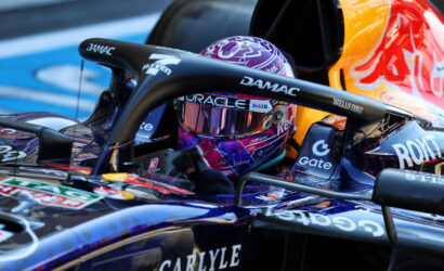 Close-up of a Formula 1 cockpit with a purple helmet and sponsor logos (DAMAC, Wells Fargo).