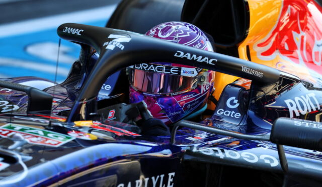 Close-up of a Formula 1 cockpit with a purple helmet and sponsor logos (DAMAC, Wells Fargo).