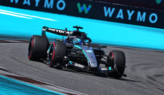 Mercedes-AMG Petronas Formula One car taking a left turn on a race track, blue run-off wall in the background.