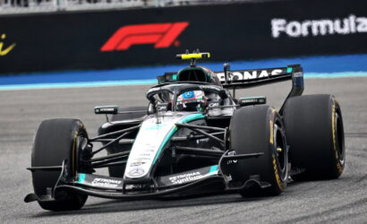 Mercedes F1 car (Petronas/Mercedes-AMG) speeding on a race track, front view with sponsor logos visible.",