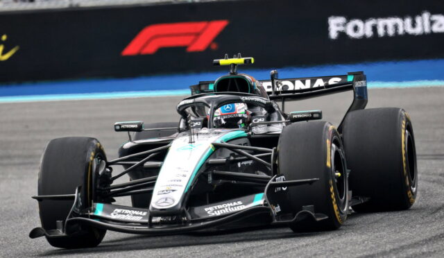 Mercedes F1 car (Petronas/Mercedes-AMG) speeding on a race track, front view with sponsor logos visible.",