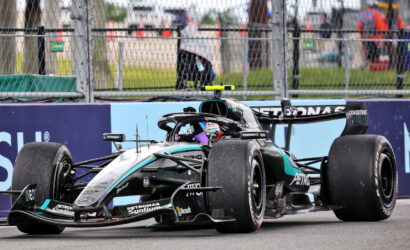 Mercedes-AMG Petronas Formula 1 car on the track, front wing low to the ground, behind safety barriers and fencing.