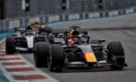 Red Bull Formula 1 car leading a pack around a tight corner on a race track.