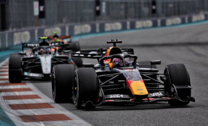Red Bull Formula 1 car leading a pack around a tight corner on a race track.