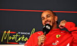 Smiling man in a red Ferrari jacket speaks into a microphone during a press interview at an event backdrop that reads Montreux.