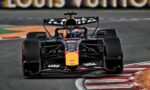 Red Bull Racing Formula 1 car charges into a left-hand corner, front-on view with sponsor logos visible on the nose and wings.