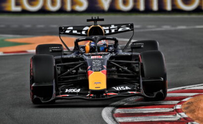 Red Bull Racing Formula 1 car charges into a left-hand corner, front-on view with sponsor logos visible on the nose and wings.