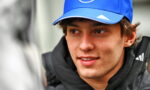 Young man wearing a blue cap with a white logo, looking to the left.