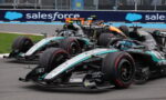 Three Mercedes Formula 1 cars race side by side on a track, with a blue Salesforce banner in the background.