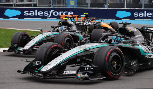 Three Mercedes Formula 1 cars race side by side on a track, with a blue Salesforce banner in the background.