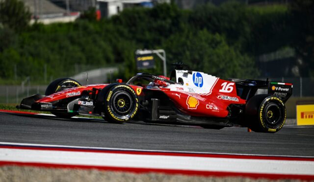 Two red Ferrari Formula 1 cars racing side by side on a track, with sponsor logos like HP and Shell visible.