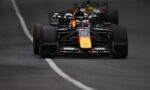 Front view of a Red Bull Racing Formula 1 car racing toward the camera, nose and front wing in focus on a dark track with a white line left of center.