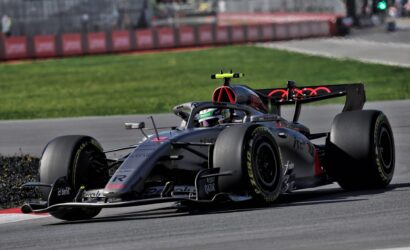 Mercedes Formula 1 car speeding on a race track with a bright yellow cockpit camera, blurred barriers in the background.