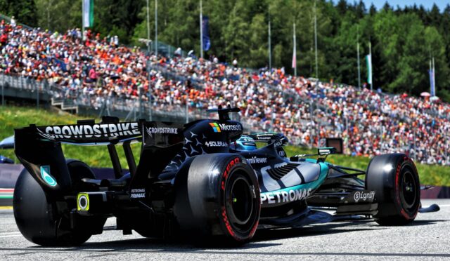 Race cars on track with a large crowd in the stands; close-up of a Formula 1 car featuring Petronas branding and a prominent rear wing reading 'CROWDSTRIKE'