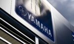 Close-up of a Yamaha sign on a metal storefront, showing the Yamaha logo and wordmark.