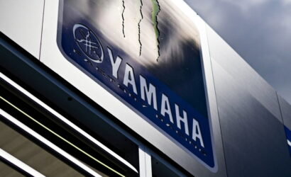 Close-up of a Yamaha sign on a metal storefront, showing the Yamaha logo and wordmark.