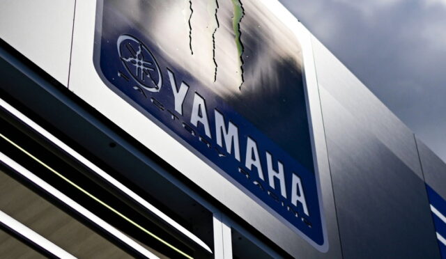 Close-up of a Yamaha sign on a metal storefront, showing the Yamaha logo and wordmark.