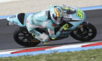 Moto racer in teal suit leans into a sharp turn on a race track aboard a turquoise Leopard Vulcain bike