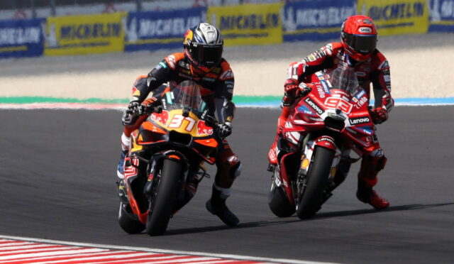 Two motorcycle racers lean into a left-hand curve on a race track, bike numbers 37 and 99 leading the pack.