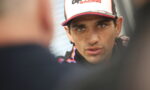 Close-up of a man in an Aprilia Racing cap speaking during an interview.