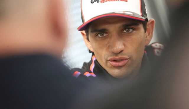 Close-up of a man in an Aprilia Racing cap speaking during an interview.