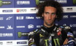 Male motorcycle racer with arms crossed, wearing a black racing suit, standing in front of a Yamaha-sponsored backdrop.