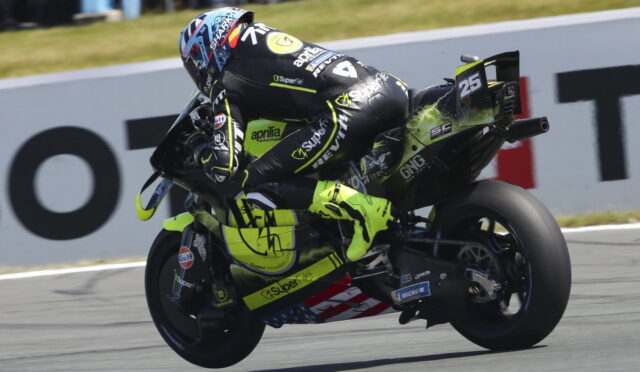 Motorcycle racer in a neon-yellow suit leans into a turn on a race track, bike number 25.