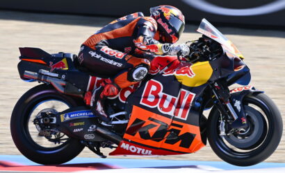 MotoGP rider on a Red Bull KTM bike leaning into a turn on a racetrack