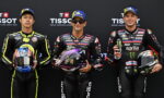 Three motorcycle racers in full leathers stand side by side holding helmets, posing against a Tissot backdrop.