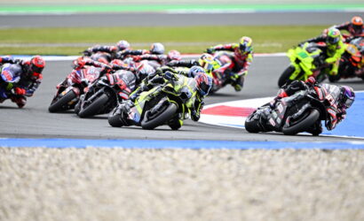 Motorcycle racers lean into a tight curve during a race on a professional track