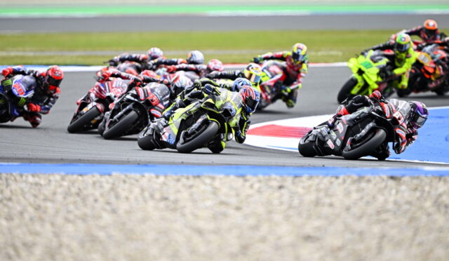 Motorcycle racers lean into a tight curve during a race on a professional track
