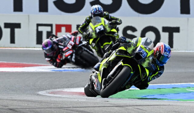 Riders on sport motorcycles leaning into a sharp turn on a race track in a high-speed race scene.