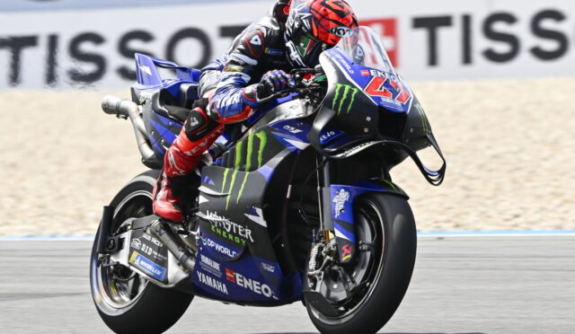 Moto racer on a blue Yamaha motorcycle, leaning into a turn with Monster Energy livery on a racetrack