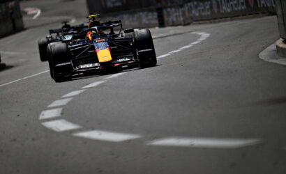 Red Bull Racing Formula 1 car rounds a tight city street corner on the race track.