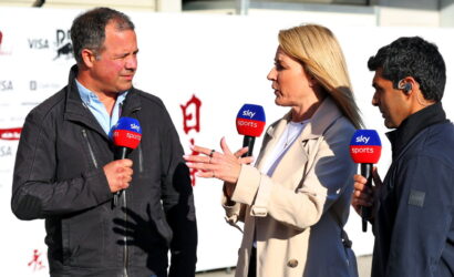 Three reporters interview a man outdoors, holding Sky Sports microphones as the woman speaks animatedly between them.