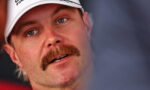 Close-up of a man with a red mustache wearing a white cap, looking slightly to the side.