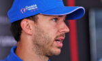 Side profile of a man wearing a blue cap with the 'Change the World' logo, speaking or listening.