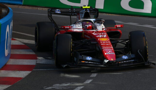 Red Ferrari Formula 1 car (#44) navigates a track corner with sponsor logos visible (Shell, IBM, HP).