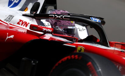 Close-up of a Formula 1 cockpit with a glittery purple helmet, red car body, and sponsor logos (HP, ZYN, Ferrari).