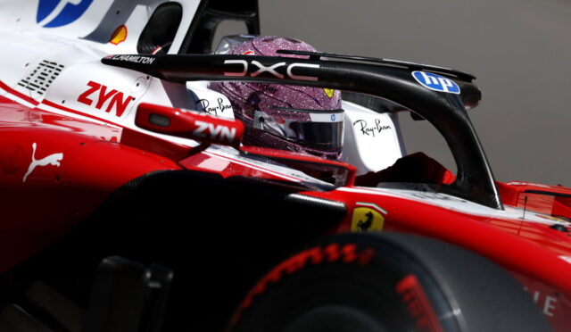 Close-up of a Formula 1 cockpit with a glittery purple helmet, red car body, and sponsor logos (HP, ZYN, Ferrari).